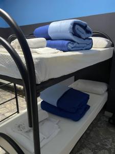 那不勒斯Alexander hostel的双层床,配有蓝色和白色的毛巾