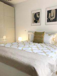 凯奇凯梅特Elizabeth Garden Premium Apartment的卧室内的一张大白色床,配有两张照片
