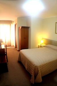 利马旋律酒店的酒店客房设有床、梳妆台和窗户。