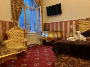 布拉格Hotel Klarinn Prague Castle的一间卧室配有一张床、一把椅子和电视