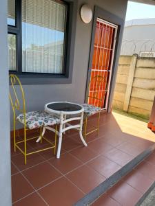 彼得马里茨堡Ikhaya guesthouse2的庭院配有两把椅子和一张桌子及椅子