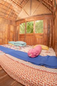 斯勒曼Villa Kampung Ayem Riverside的木制客房内的一张床位,上面有两个枕头