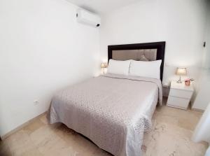 圣路易斯·德·萨比尼尔Centro Playa de Sabinillas Manilva的卧室配有白色床和白色棉被