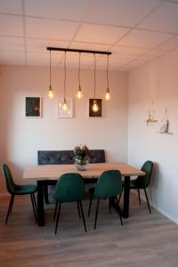 布伦瑞克Apartment im Herzen der Stadt的一间带木桌和绿色椅子的用餐室