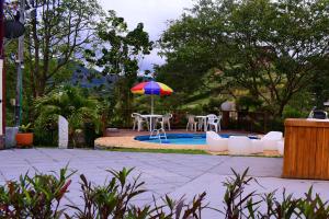 El PeñolFinca en Guatapé a solo minutos de la piedra, con Jacuzzi & piscina的庭院配有桌椅和遮阳伞。