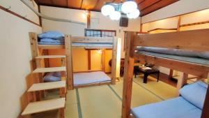 大阪Hostel Caranashi的客房设有三张双层床和一张桌子。