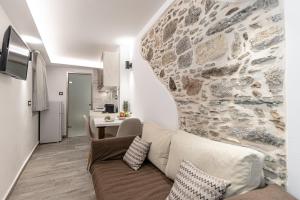 纳克索乔拉Mariet Naxos Spa & Suites的带沙发和石墙的客厅