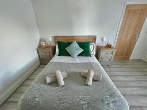 班戈Spacious & Modern 4 Bedroom Holiday Home Gwynedd的一间卧室配有一张带绿色枕头的大床