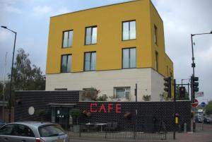 伦敦Abbey Point Hotel的前面有咖啡馆标志的黄色建筑