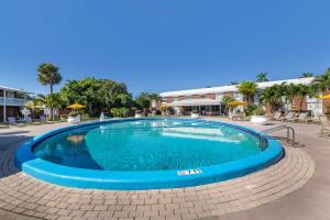 西棕榈滩贝斯特韦斯特普勒斯棕榈滩湖群酒店的度假村内带椅子和遮阳伞的大型游泳池