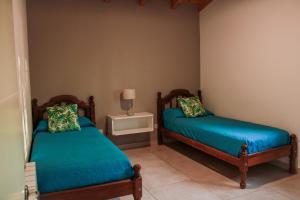 马拉圭Departamento Parras del Abuelo 2的一间卧室配有两张床和一张带台灯的桌子