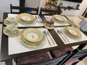 怡保Sunway Onsen COSY HOME Tambun Ipoh的桌子上摆着盘子和餐具