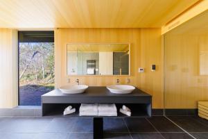 白马村Hakuba Jolie Maison by Jade Group的一间带两个盥洗盆和大镜子的浴室