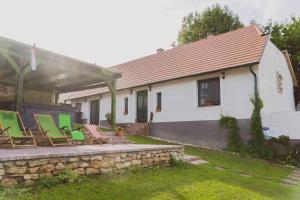 大瓦若尼Holiday home in Nagyvazsony - Balaton 43410的一组椅子坐在房子旁边的石墙上