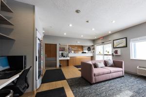 德卢斯AmericInn by Wyndham Duluth的带沙发和电视的客厅