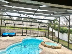 克莱蒙Dreamy Family Pool House的温室中的游泳池,设有大型游泳池