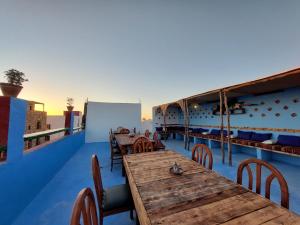 塔哈佐特Orca Surf House的屋顶上设有木桌和椅子的餐厅