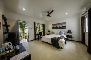 DaanbantayanOcean Vida Beach and Dive Resort的一间卧室配有一张床和吊扇
