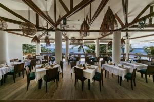 DaanbantayanOcean Vida Beach and Dive Resort的餐厅设有白色的桌椅,享有海景。