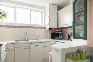 伦敦Beautiful 3BD Flat in Archway London的白色的厨房配有白色橱柜和水槽