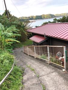 串本町お宿　弘法湯的一座红色屋顶和围栏的房子