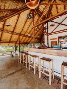 MangochiThe Makokola Retreat的酒吧,有木凳,有人坐在酒吧