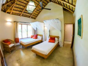 MangochiThe Makokola Retreat的一间卧室设有两张床和窗户。