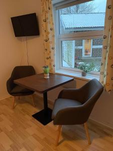 维堡维伯格汽车旅馆的一间带桌子和两把椅子的用餐室以及窗户。