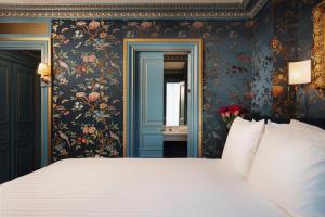 巴黎Maison Proust, Hotel & Spa La Mer的一间卧室配有一张大床和花卉壁纸