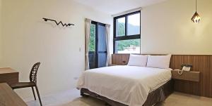 绿岛微笑海洋轻旅的一间卧室配有一张床、一张桌子和一个窗户。