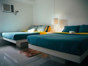 公主港Wanderlust Bed & Breakfast的蓝色和黄色的客房内的两张床