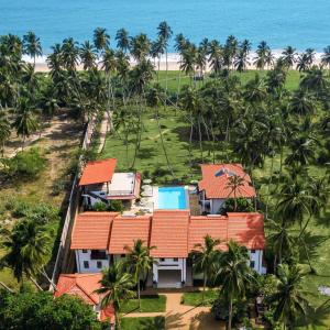 坦加拉Green Parrot Hotel - ROOMS ONLY, NO MEALS的享有棕榈树和海洋度假村的空中景致