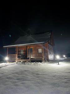 厄尔科Domki Mazurskie Zacisze Jeziora Sunowo的雪中的一个小木屋
