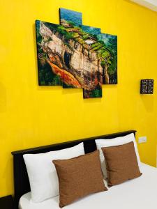 尼甘布法恩维尔斯旅馆的一张黄色墙上有四幅画的床铺