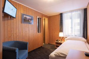 格林德尔瓦尔德瑞士山圣母峰洛奇酒店的一间酒店客房,配有一张床和一台电视