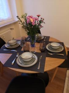 热那亚Palazzo Penco Apartment的一张桌子,上面有盘子和花瓶