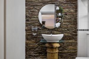 卡迪根卡莫尔甘宾馆的浴室设有水槽和石墙上的镜子