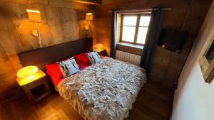谷雪维尔l’escalade 3的一间卧室配有一张带红色枕头的床和一扇窗户