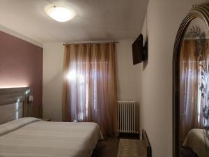 卡斯蒂奥内·德拉·佩雷索斯卡纳帕餐厅酒店的一间小卧室,配有两张床和窗户