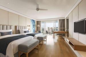 三亚三亚丽禾温德姆酒店(首日免费迷你吧+旅拍)的酒店客房设有两张床和一台平面电视。