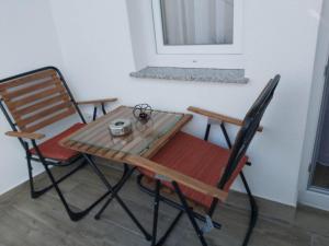普里兹伦Studio Apartment - Prizren的一张桌子和两把椅子坐在窗边