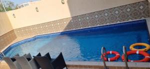 吉达Luxury villas for rent的一个带两个红色救生员和双杠的游泳池