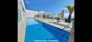 巴西利亚Flat hotel saint moritz的毗邻大海的带椅子和遮阳伞的游泳池
