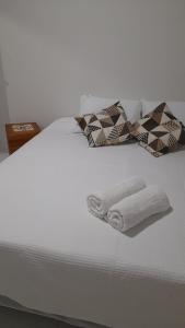 阿拉亚尔达茹达Pousada Sossego do Pirata的一张白色的床,上面有两张折叠毛巾