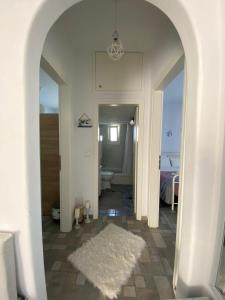 莫罗斯帕罗Molos Sea View House - Paros Greece的一条铺有白色地毯的走廊和一间浴室