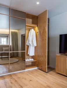 波尔图Casa da Companhia Hotel, Vignette Collection的客房设有带镜子的衣柜和电视。