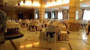 阿斯塔纳O Azamat的宴会厅,室内配有白色的椅子和桌子