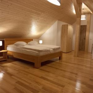 普雷代亚尔Vila Cedra的一间卧室配有一张床,铺有木地板