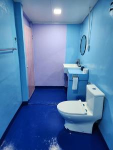珍南海滩壁虎宾馆的蓝色的浴室设有卫生间和两个盥洗盆