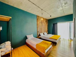 卡兹贝吉Hotel Misty Mountain的一间卧室设有两张床和绿色的墙壁